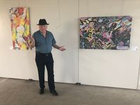 M. Wimmershoff steht in der Fabrik Alsen vor 2 Kunstwerken